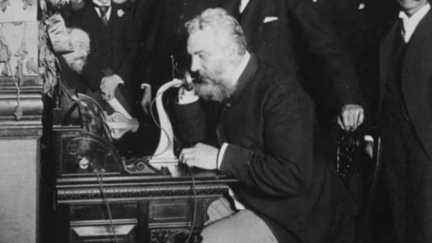 man using first telephone ever invented